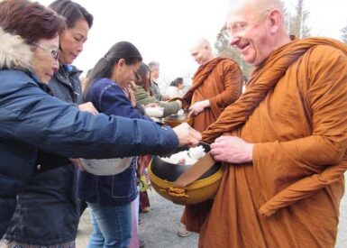 Buddhistmunker får mat på almissevandring